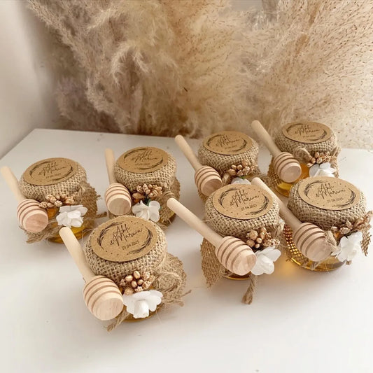 Festliches Honigglas als personalisiertes Gastgeschenk für Hochzeit, Taufe und Kommunion, elegant dekoriert mit Holzlöffel und natürlicher Deko