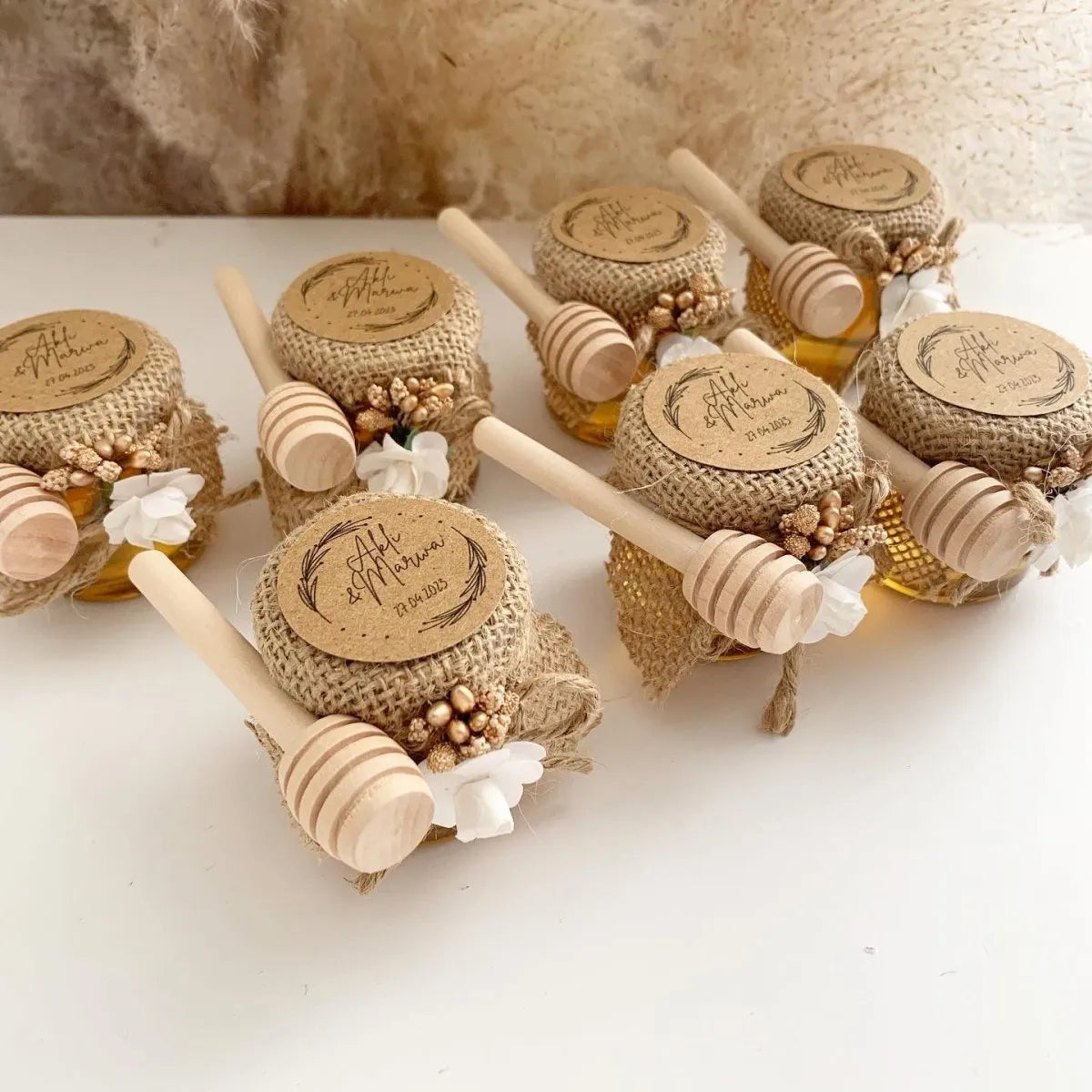 Festliches Honigglas als personalisiertes Gastgeschenk für Hochzeit, Taufe und Kommunion, elegant dekoriert mit Holzlöffel und natürlicher Deko
