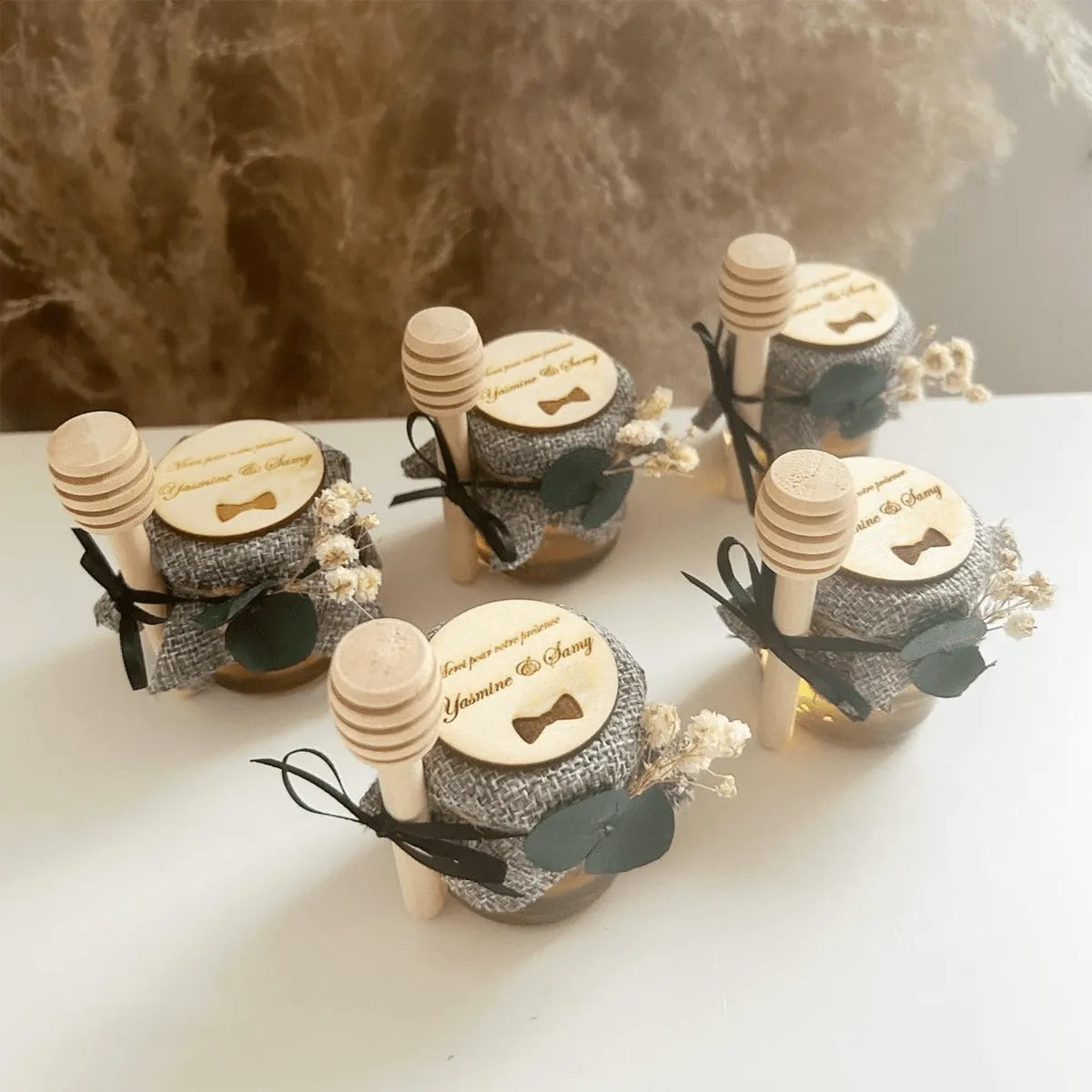 Honigglas Kostüm als personalisiertes Gastgeschenk zur Hochzeit, elegant dekoriert mit Schleife, Holzlöffel und natürlicher Deko