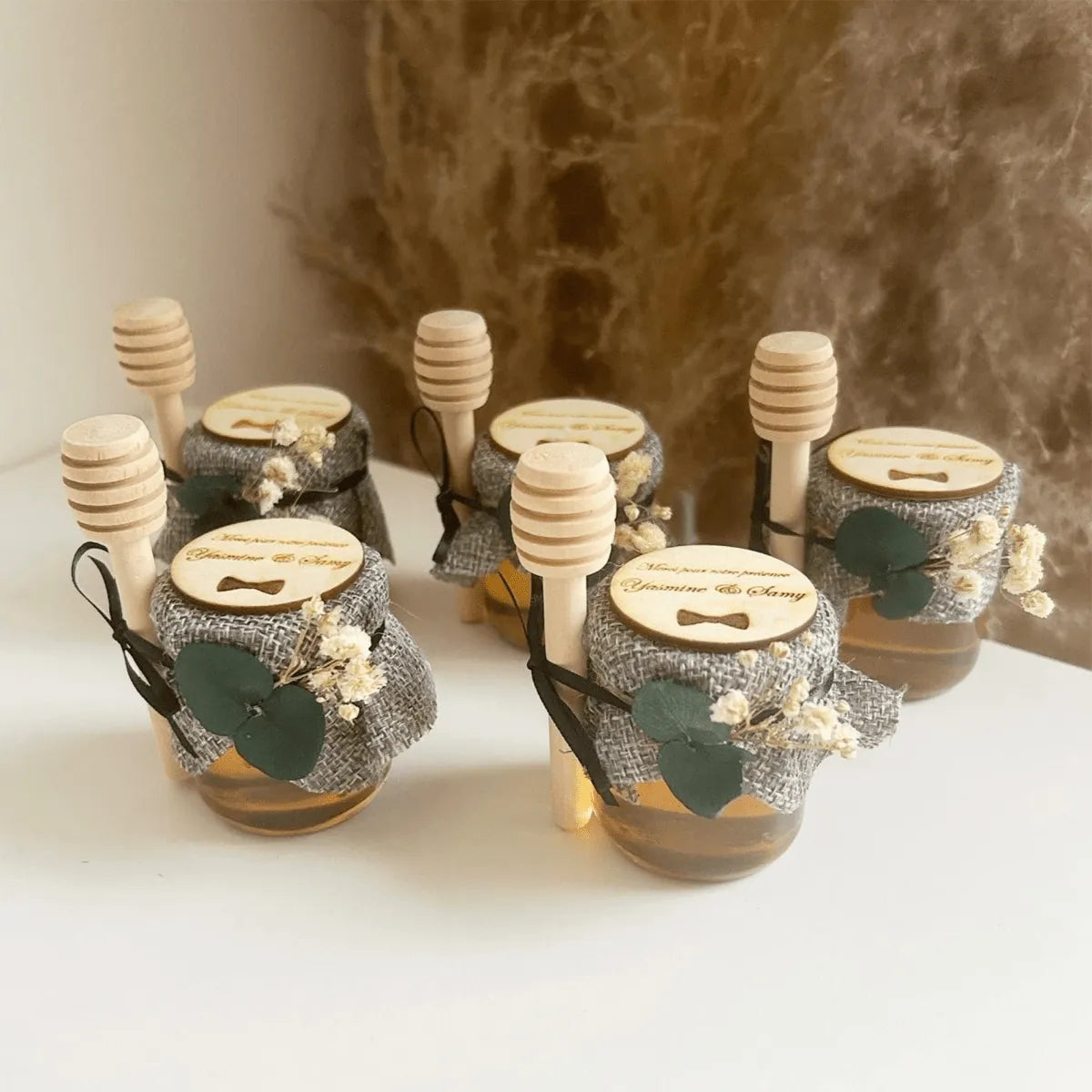 Honigglas Kostüm als personalisiertes Gastgeschenk zur Hochzeit, elegant dekoriert mit Schleife, Holzlöffel und natürlicher Deko