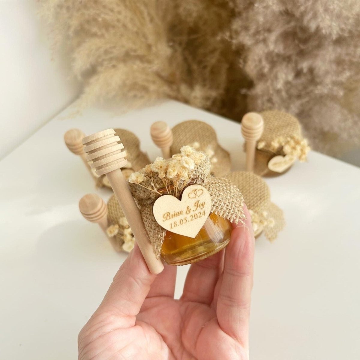 Honigglas Love als personalisiertes Gastgeschenk für Hochzeit und Taufe, mit Herzanhänger, Schleife und Holzlöffel