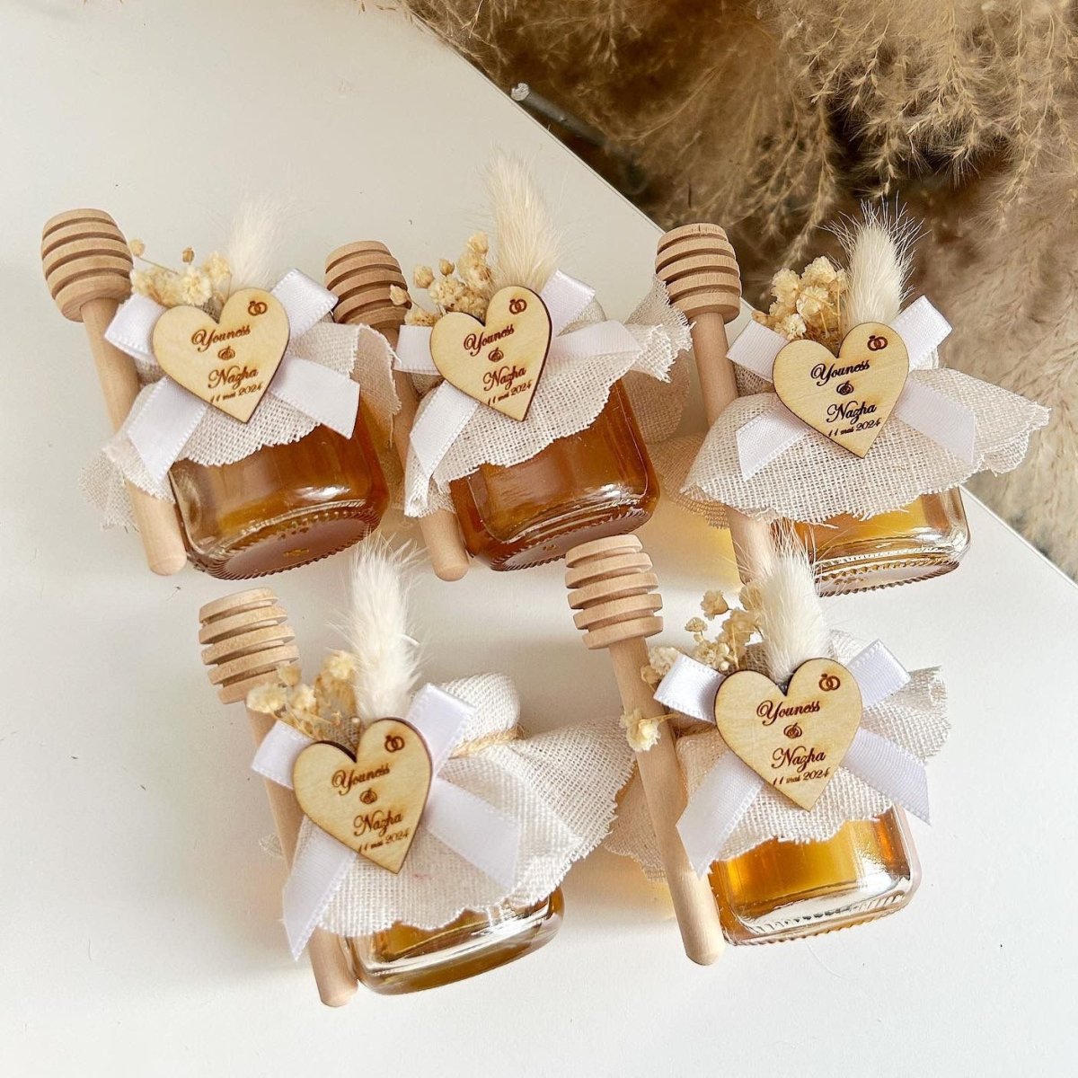 Honigglas Maya als personalisiertes Gastgeschenk für Hochzeit und Taufe, dekoriert mit Schleife, Herzanhänger und Holzlöffel