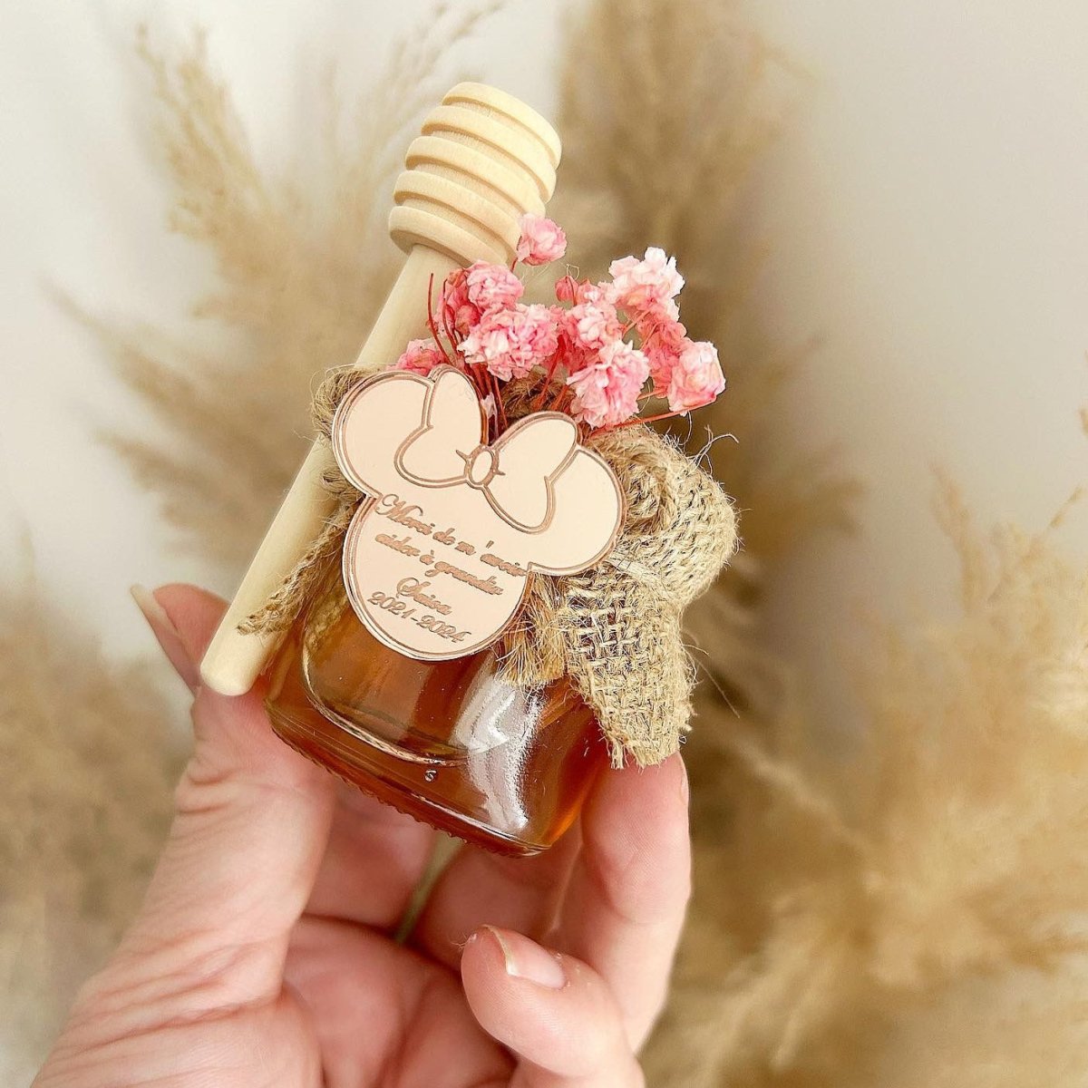 Honigglas Mimi als personalisiertes Gastgeschenk zur Taufe und Kommunion, dekoriert mit Blumen, Schleife und Holzlöffel