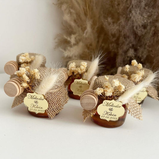 Luxus-Honigglas als personalisiertes Gastgeschenk für Hochzeit und Taufe, mit eleganter Dekoration, Schleife und Holzlöffel