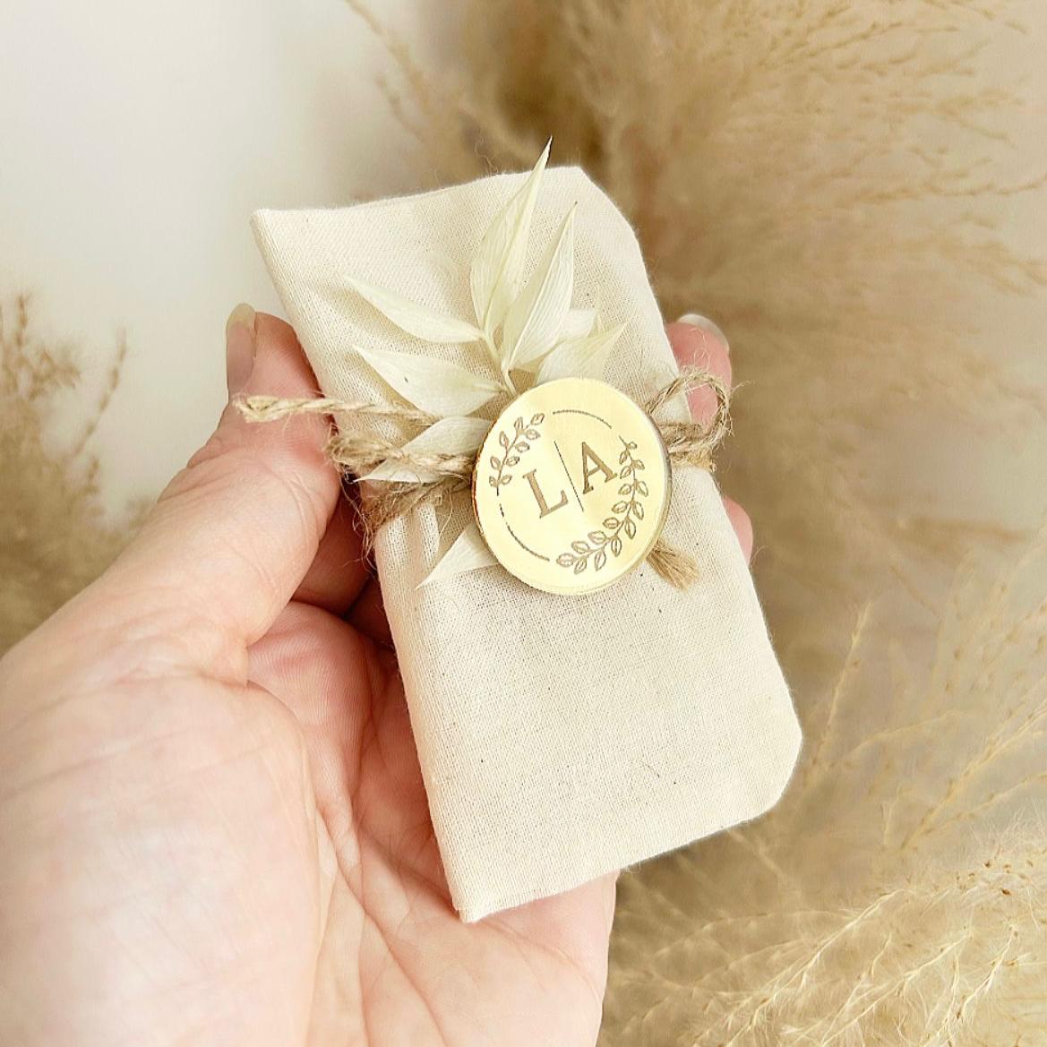 MON CADEAU INVITE - Personalisierte Seife Dune Gold im Stoffbeutel mit Juteband, rundem Etikett und getrockneten Blättern, elegantes Gastgeschenk für Hochzeit oder besonderes Event