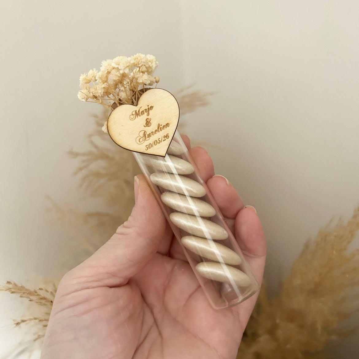 Transparenter Tube mit Zuckermandeln Love in Perlmuttoptik, graviertem Holzherz und elfenbeinfarbenen Trockenblumen